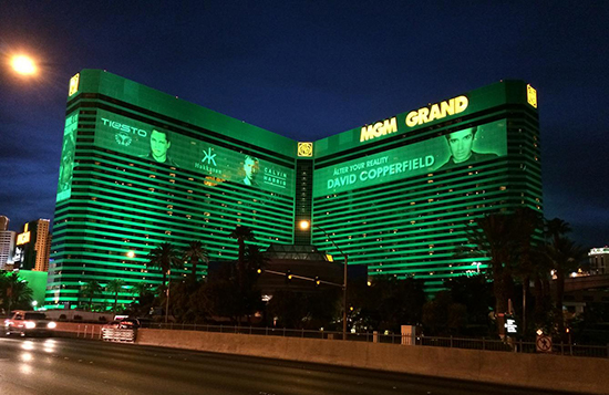 The MGM Grand hotel & Casino lit up green at night.