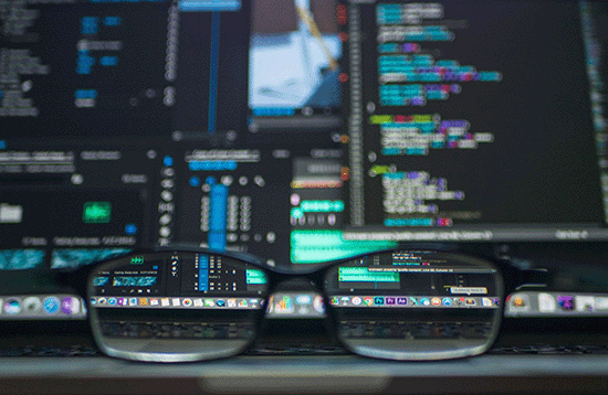 glasses sit in front of a computer coding set up