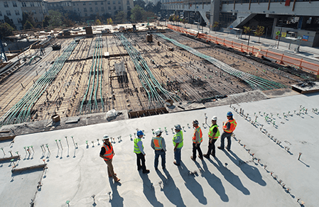 A group of construction workers surveying a construction site.