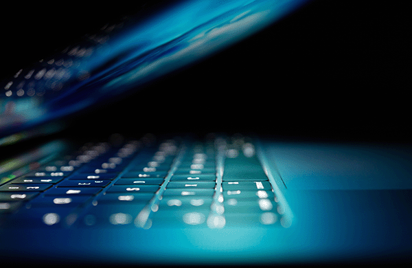 Closeup of a computer keyboard with bluish lighting